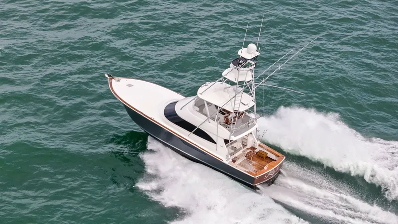 Slide: The Image of Aerial View of Viking 55 Convertible The Viking 55 Convertible is captured gracefully cutting through the water, showcasing its sleek design and powerful performance. The spacious aft deck is visible, highlighting ample space for fishing or leisure activities. The vessel's elegant lines and - 7584942