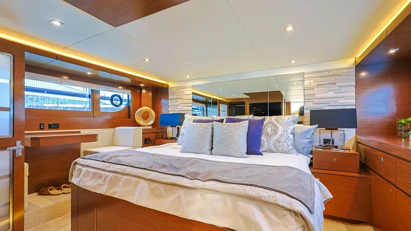Slide: The Image of Master Stateroom with Luxurious Finishes The master stateroom of the Sol Mate showcases exquisite craftsmanship with rich wood paneling and elegant lighting. The spacious layout features a plush bed adorned with soft linens and ample storage, creating a serene retreat. Large windows allow natura - 7661148