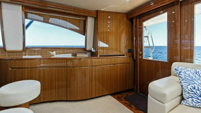 Slide: The Image of Salon Interior with Ocean View The salon of the 2013 Viking 55 Convertible 'Hot Spot' features luxurious wood finishes and ample natural light. Large windows provide stunning ocean views, enhancing the sense of space and tranquility. Comfortable seating and elegant cabinetry combine fu - 7594238