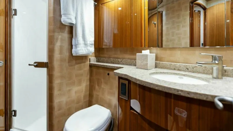 Slide: The Image of Elegant Ensuite Head with Shower This well-appointed ensuite head features a sleek glass-enclosed shower and a modern vanity with a polished countertop. The rich wood cabinetry offers ample storage, while the recessed lighting adds a touch of sophistication. The space combines functional - 7594254