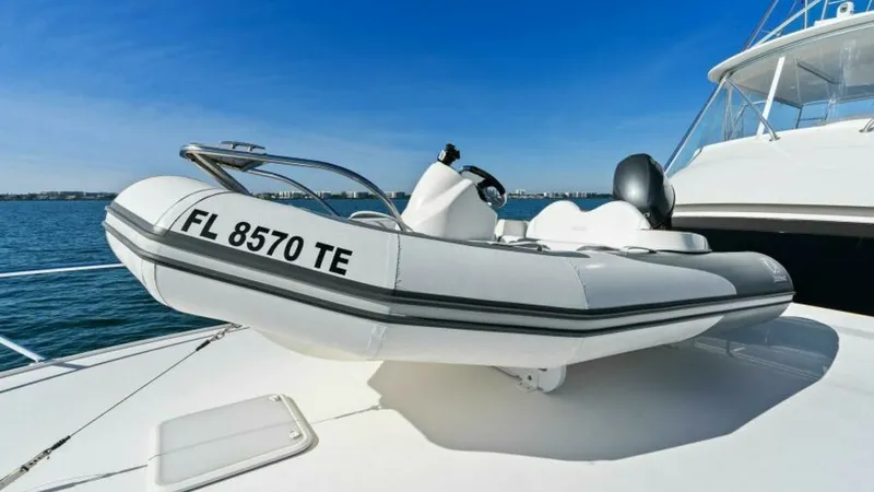 Slide: The Image of Tender on Foredeck A sleek tender is securely positioned on the foredeck of the 2013 Viking 55 Convertible, 'Hot Spot'. The tender complements the yacht's versatility, ready for quick excursions or leisurely exploration. The open sky and expansive sea views enhance the appe - 7594286