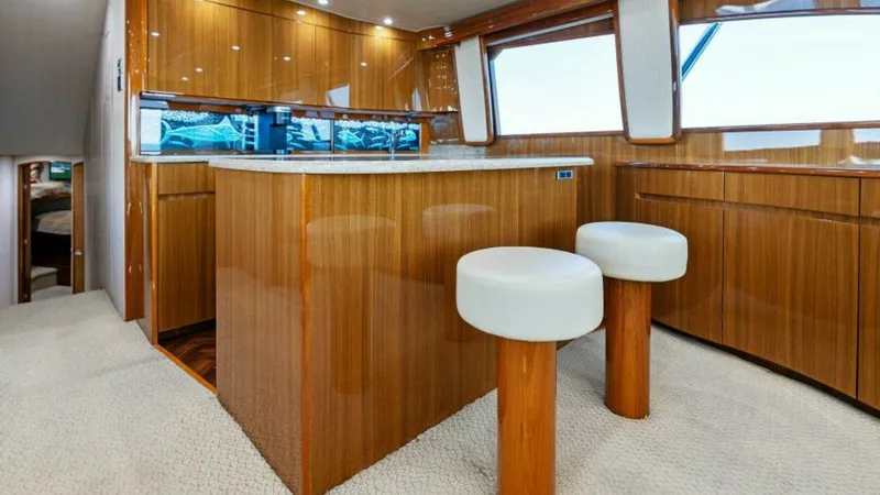 Slide: The Image of Elegant Galley with Bar Stools The galley of the 2013 Viking 55 Convertible exudes sophistication with its high-gloss wood finishes and modern design. The spacious countertop, complemented by two sleek bar stools, offers a perfect spot for casual dining or entertaining. Large windows f - 7594239