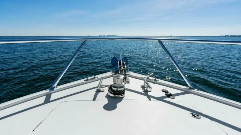 Slide: The Image of Bow View with Anchor System This image showcases the sleek bow of the 2013 Viking 55 Convertible, featuring a robust anchor system ideal for secure mooring. The expansive deck provides a clear, unobstructed view of the horizon, enhancing the vessel's appeal for open-water cruising. - 7594288