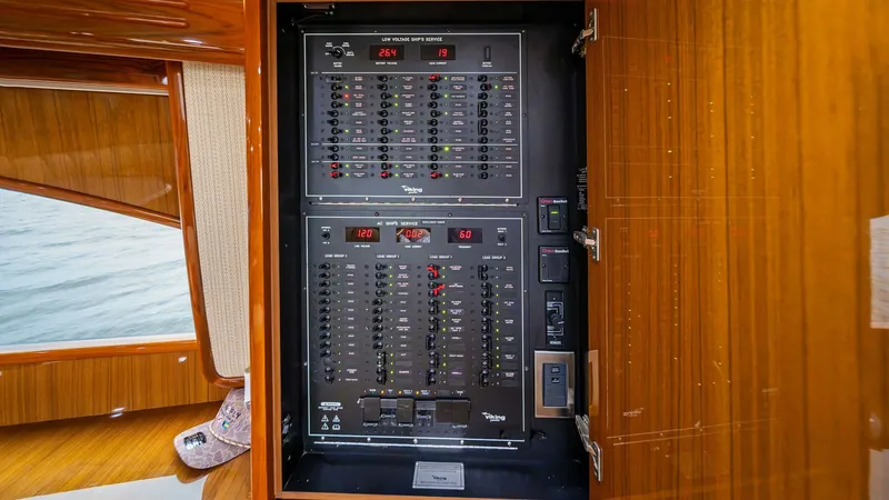 Slide: The Image of Electrical Panel with Wood Finish The image showcases the sophisticated electrical panel of the Viking 55 Convertible, featuring a sleek black control interface set within a finely crafted wooden cabinet. The panel provides easy access to essential systems, ensuring seamless operation of - 7962067