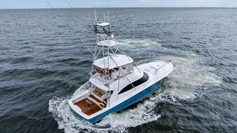 Slide: The Image of Aerial View of Viking 55 Convertible This aerial shot captures the sleek design of the 2013 Viking 55 Convertible 'Hot Spot' gliding through open waters. The vessel showcases a spacious aft deck perfect for fishing or leisure, complemented by a sturdy flybridge with a tuna tower for optimal - 7962120