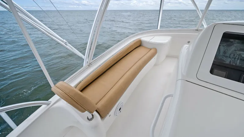 Slide: The Image of Flybridge Seating Area Experience comfort and style in the flybridge seating area of the 2013 Viking 55 Convertible. The plush, tan cushion provides a relaxing spot to enjoy panoramic ocean views. The surrounding white fiberglass finish enhances the modern appeal and durability - 7962100