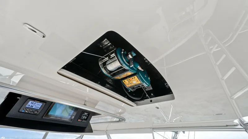 Slide: The Image of Flybridge Electronics and Reel Storage This image showcases the flybridge of the 2013 Viking 55 Convertible 'Hot Spot', featuring advanced electronic displays for navigation and fishing. The integrated reel storage compartment is a testament to the vessel's functionality, offering easy access - 7962099