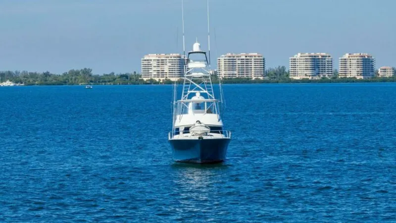 Slide: The Image of Bow View with Tower This image captures the striking bow of the 2013 Viking 55 Convertible, 'Hot Spot,' showcasing its sleek lines and robust fishing tower. The vessel's design emphasizes both performance and luxury, set against a backdrop of serene waters and coastal skylin - 7594304