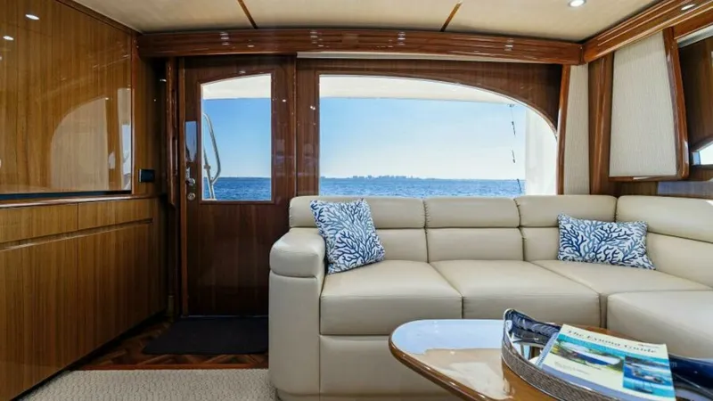 Slide: The Image of Salon with Ocean View This elegant salon aboard the 2013 Viking 55 Convertible 'Hot Spot' offers a luxurious retreat with panoramic ocean views. The plush L-shaped sofa is adorned with decorative cushions, while the high-gloss wood finishes and recessed lighting create a warm - 7594244