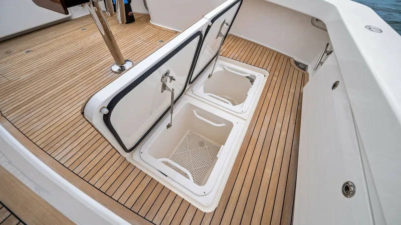Slide: The Image of Cockpit Storage Hatches Open View This image showcases the open storage hatches in the cockpit of the 2013 Viking 55 Convertible. The teak deck provides a classic and durable finish, complementing the yacht's high-quality craftsmanship. These spacious hatches offer ample storage for fishi - 7962089