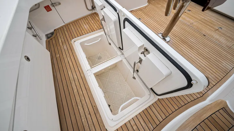 Slide: The Image of Cockpit Storage Compartments Opened This image showcases the practical storage compartments located in the cockpit of the 2013 Viking 55 Convertible. The compartments are designed for easy access and optimized space, featuring durable latches and a sleek, flush design. The teak decking adds - 7962090