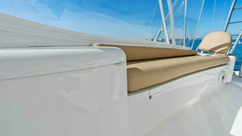 Slide: The Image of Flybridge Seating Area This image showcases the sleek and comfortable flybridge seating area on the 2013 Viking 55 Convertible. The cushioned bench provides ample space for relaxation, surrounded by a pristine white finish that complements the ocean views. The open design and s - 7594258