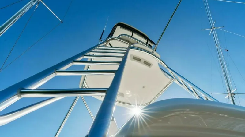 Slide: The Image of Tower and Outriggers View This striking angle showcases the sleek, polished tower of the 2013 Viking 55 Convertible, emphasizing its robust design and high-quality craftsmanship. The image highlights the shining stainless steel outriggers extending against a clear sky, enhancing t - 7594271