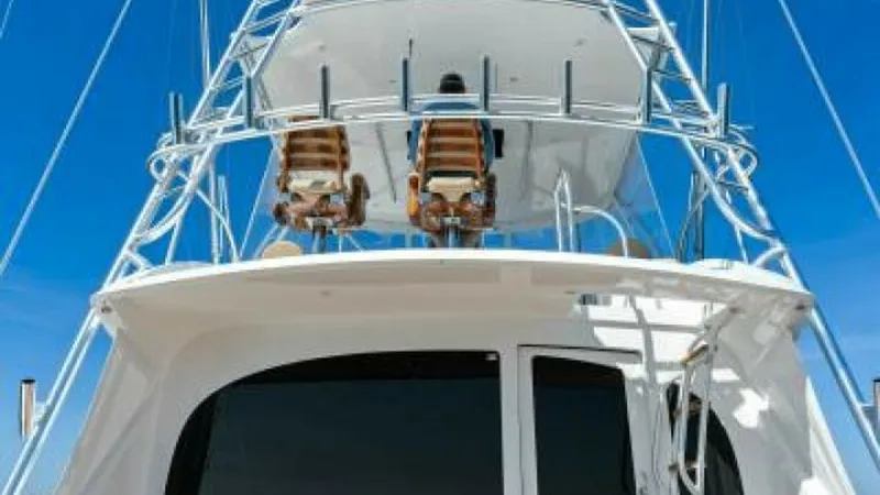 Slide: The Image of Flybridge and Tower View This image showcases the impressive flybridge and tower of the 2013 Viking 55 Convertible, 'Hot Spot'. The flybridge features twin captain chairs with a commanding view, ideal for navigating and fishing. The sleek tower structure enhances visibility and p - 7594263