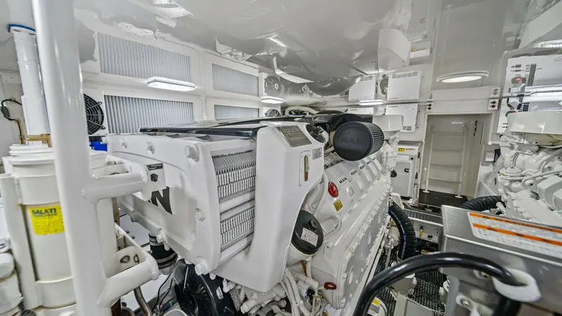 Slide: The Image of Engine Room with Twin Engines The engine room of the 2013 Viking 55 Convertible 'Hot Spot' showcases twin powerful engines meticulously installed for optimal performance. Bright overhead lighting and a pristine white finish enhance visibility and cleanliness, making maintenance straig - 7962104
