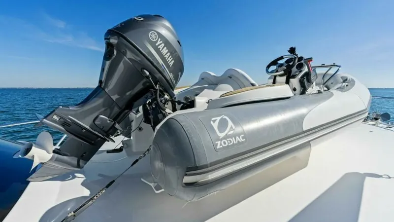 Slide: The Image of Tender on Bow with Outboard Motor This image showcases the bow area of the Viking 55 Convertible 'Hot Spot', featuring a Zodiac tender equipped with a Yamaha outboard motor. The tender is securely mounted on the bow, providing easy access for excursions. The setup reflects practical desig - 7594284