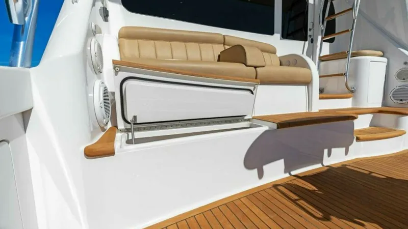 Slide: The Image of Cockpit Seating and Storage Area This image showcases the cockpit of the 2013 Viking 55 Convertible, featuring plush tan seating with integrated storage. The teak flooring adds a touch of elegance, while the strategically placed speakers promise an enhanced audio experience. A ladder lea - 7594266