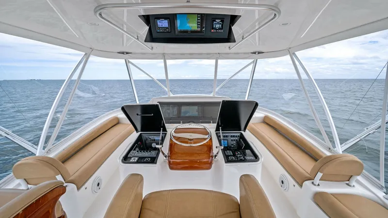 Slide: The Image of Flybridge Helm Station The helm station on the flybridge of the 2013 Viking 55 Convertible offers a commanding view of the open sea. Featuring state-of-the-art navigation displays and polished wood accents, this area combines functionality with luxury. Comfortable seating and e - 7962096