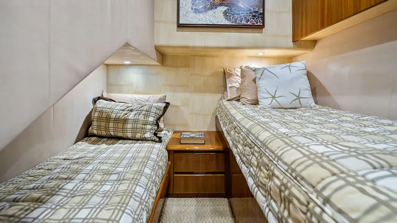 Slide: The Image of Twin Guest Stateroom This inviting twin guest stateroom features two comfortable single beds with elegant bedding, perfect for accommodating additional guests. The room is enhanced by warm wood cabinetry and soft ambient lighting, creating a cozy and relaxing atmosphere. A ce - 7962082