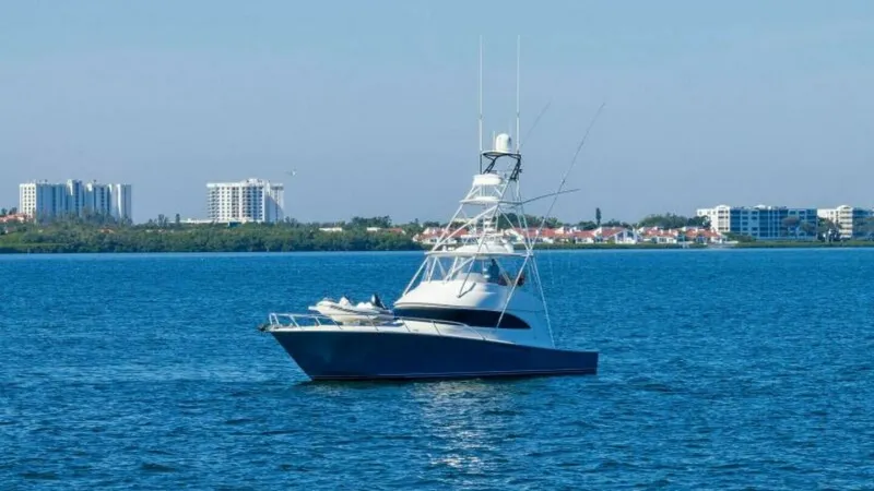 Slide: The Image of Side Profile of Viking 55 Convertible This image showcases the sleek side profile of the 2013 Viking 55 Convertible, 'Hot Spot.' The vessel is pictured cruising smoothly against a serene blue backdrop, emphasizing its elegant design and powerful build. The tower and antennas are prominently v - 7594305