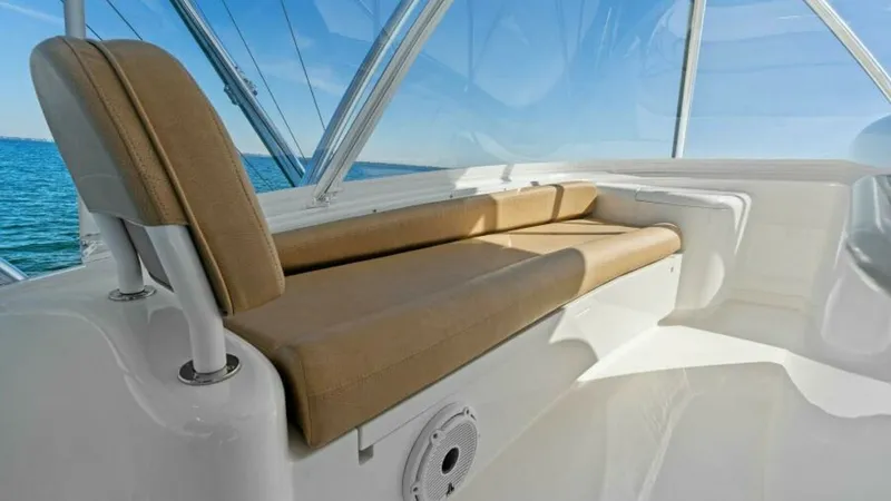Slide: The Image of Flybridge Seating Area This image showcases the spacious flybridge seating area on the 2013 Viking 55 Convertible. The comfortable, tan cushioned bench provides an inviting space for relaxation, offering panoramic views through the clear, protective enclosure. Ideal for sociali - 7594259