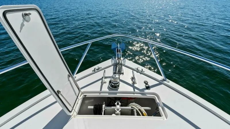 Slide: The Image of Bow Anchor Locker and Pulpit This image showcases the bow of the Viking 55 Convertible, highlighting the practical anchor locker with a neatly stored windlass system. The open hatch reveals ample storage for anchoring equipment, ensuring easy access and operation. The stainless steel - 7594289