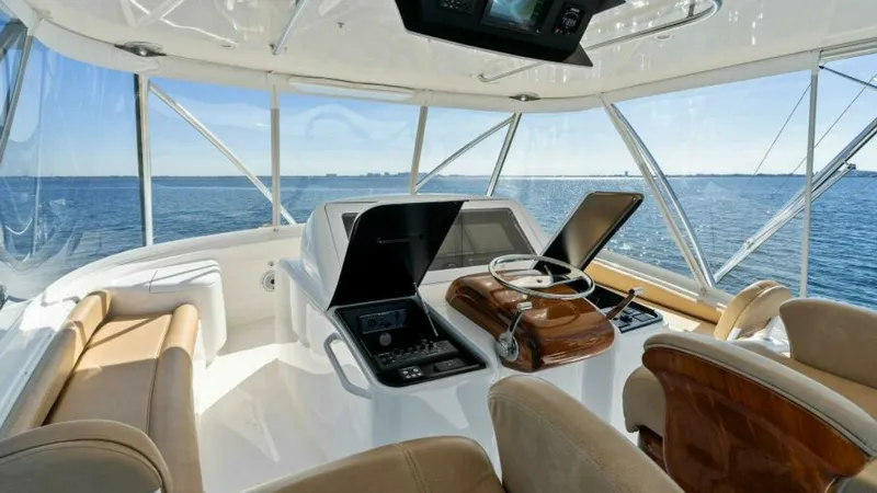 Slide: The Image of Flybridge Helm with Panoramic Views The flybridge helm of the 2013 Viking 55 Convertible offers stunning panoramic views, perfect for navigating open waters. Equipped with state-of-the-art navigation systems and ergonomic controls, the helm ensures a seamless sailing experience. Plush seati - 7594273
