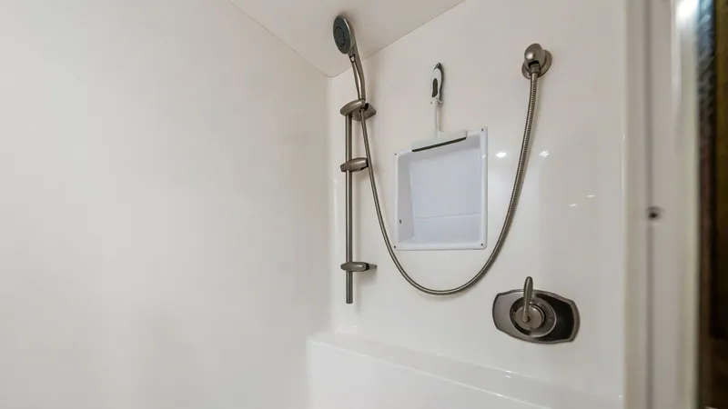 Slide: The Image of Enclosed Shower in Guest Head This image showcases the enclosed shower area within the guest head of the 2013 Viking 55 Convertible. Featuring sleek stainless-steel fixtures and a practical handheld showerhead, the space is designed for both functionality and style. The clean white su - 7962073