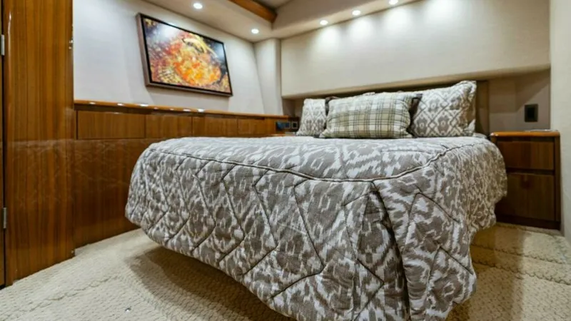 Slide: The Image of Master Stateroom with Queen Bed The master stateroom of the 2013 Viking 55 Convertible exudes luxury with its plush queen bed adorned with a stylish comforter and accent pillows. Rich wood finishes and soft carpeting enhance the cozy ambiance, while recessed lighting provides a warm, in - 7594233