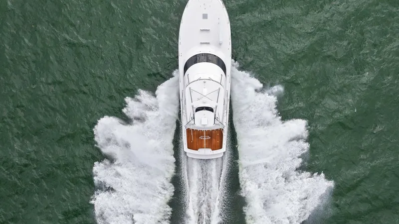 Slide: The Image of Aerial View of Viking 55 Convertible This dynamic aerial shot captures the sleek design of the 2013 Viking 55 Convertible as it cuts through the water. The vessel's elegant hull and spacious flybridge are prominently displayed, highlighting its superior craftsmanship. The wake behind the boa - 7962125