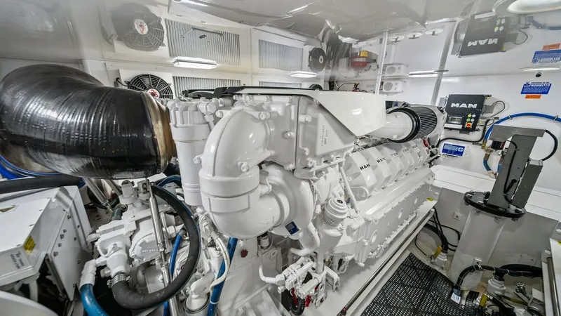 Slide: The Image of Engine Room with MAN Engines This image showcases the engine room of the 2013 Viking 55 Convertible, featuring powerful MAN engines. The space is meticulously organized, with a clean, white finish that enhances visibility and maintenance. Advanced engineering and efficient layout ens - 7962109