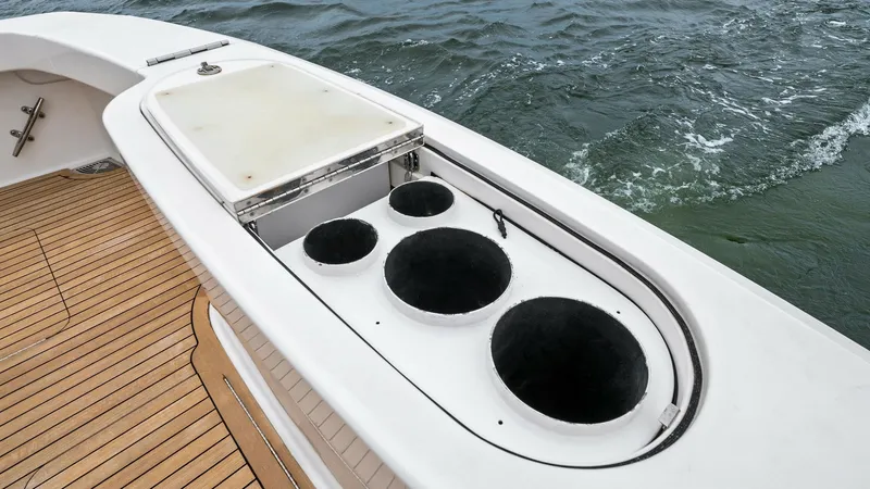 Slide: The Image of Cockpit Bait Station with Storage This image showcases the cockpit bait station of the 2013 Viking 55 Convertible, featuring a well-designed layout for efficient fishing expeditions. The station includes multiple rod holders and a large storage compartment, all set against a durable teak - 7962088