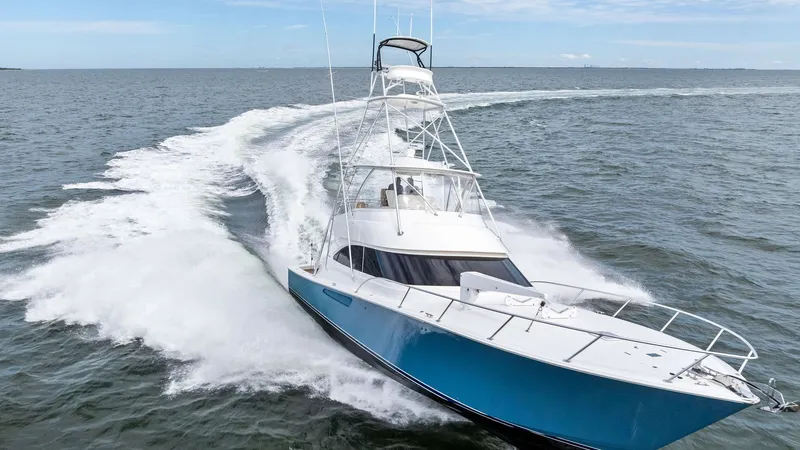 Slide: The Image of Viking 55 Convertible in Action The 2013 Viking 55 Convertible, 'Hot Spot', showcases its sleek design and powerful performance as it glides through open waters. The striking blue hull complements the vessel's robust profile, while the flybridge provides an elevated vantage point for na - 7962121