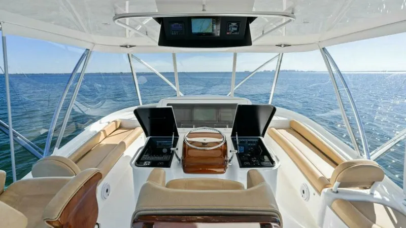 Slide: The Image of Flybridge Helm Station with Panoramic Views The helm station of the 2013 Viking 55 Convertible 'Hot Spot' showcases a sophisticated layout with dual captain chairs and state-of-the-art navigation equipment. The expansive flybridge offers unobstructed panoramic views, while the plush seating provide - 7594231