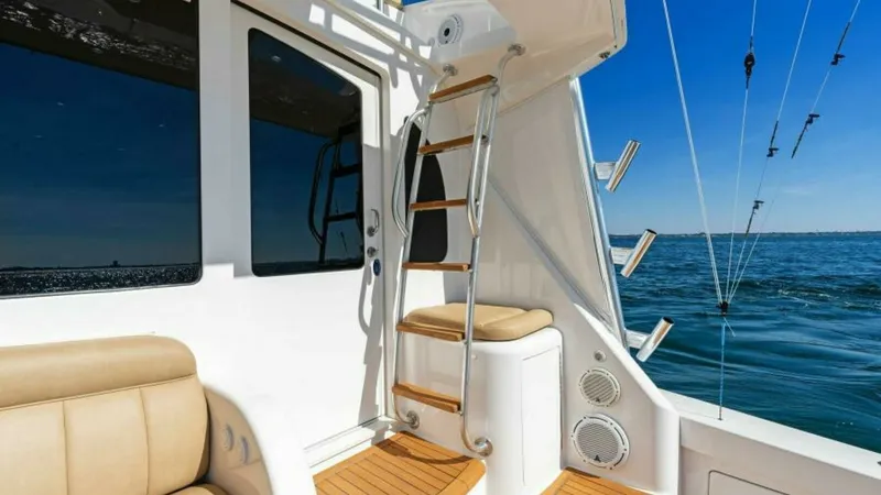 Slide: The Image of Cockpit with Ladder Access This image showcases the cockpit area of the 2013 Viking 55 Convertible. The teak decking adds a touch of elegance, while the stainless steel ladder provides easy access to the flybridge. Comfortable upholstered seating is perfect for relaxation, compleme - 7594265