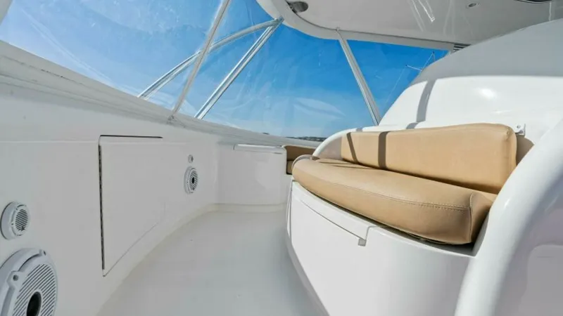 Slide: The Image of Flybridge Seating Area The flybridge of the Viking 55 Convertible features plush, tan cushioned seating, offering comfort and style while cruising. The expansive glass enclosure provides panoramic views and protection from the elements, enhancing the open-air experience. The cl - 7594256