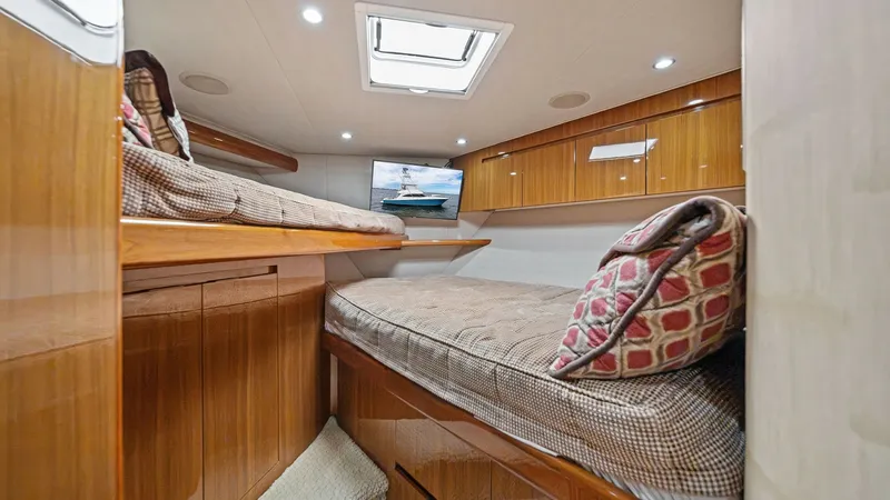 Slide: The Image of Guest Stateroom with Twin Bunks This inviting guest stateroom features twin bunk beds, offering comfortable accommodation for guests. Rich wood finishes and ambient recessed lighting create a warm and cozy atmosphere. The room is equipped with ample storage and a skylight for natural il - 7962075