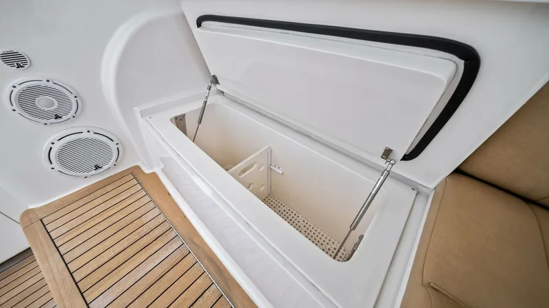 Slide: The Image of Cockpit Storage and Seating Area This image showcases the spacious cockpit storage area of the 2013 Viking 55 Convertible. The built-in storage compartment, complete with sturdy hinges and a sleek design, offers ample space for gear and essentials. The adjacent cushioned seating provides - 7962091
