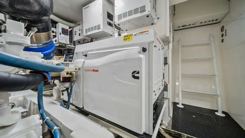 Slide: The Image of Engine Room with Generator View This image showcases the meticulously organized engine room of the Viking 55 Convertible, featuring a prominently placed Cummins Onan generator. The clean, well-lit space highlights the advanced engineering and efficient layout typical of Viking craftsman - 7962106