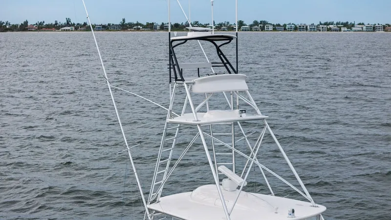 Slide: The Image of Flybridge and Tuna Tower This image showcases the flybridge and tuna tower of the 2013 Viking 55 Convertible, 'Hot Spot'. The sleek design of the tower provides an elevated vantage point, ideal for spotting fish and navigating with ease. The flybridge features comfortable seating - 7962118