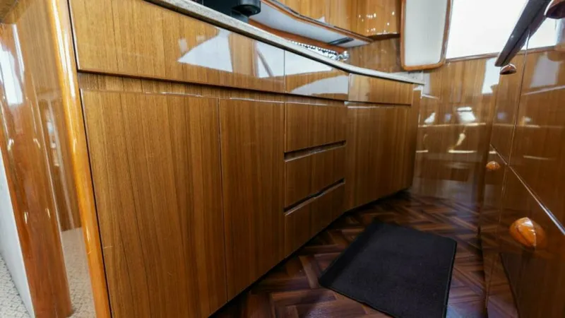 Slide: The Image of Galley with Wood Cabinetry This image showcases the sleek and modern galley of the 2013 Viking 55 Convertible. The space features beautifully crafted wood cabinetry with a high-gloss finish, providing ample storage. The elegant design is complemented by a polished countertop, enhan - 7594240