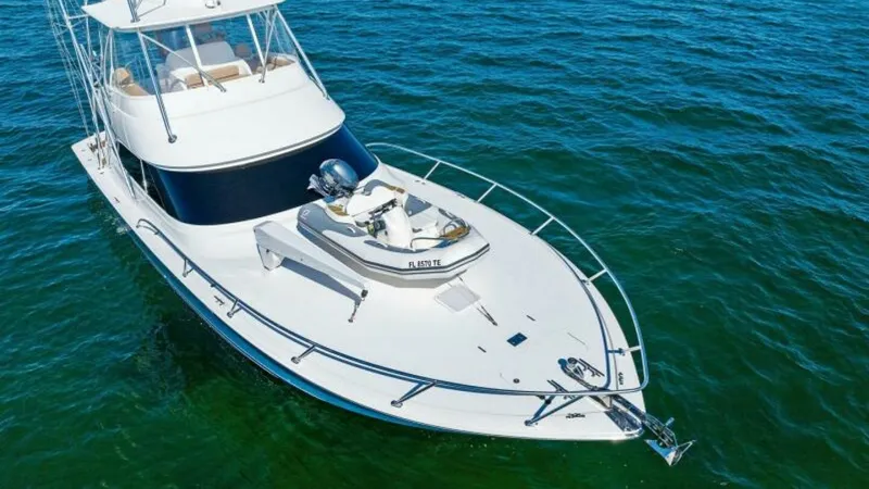 Slide: The Image of Bow with Tender and Railings The bow of the 2013 Viking 55 Convertible showcases sleek lines with polished stainless steel railings for safety and style. A compact tender is securely mounted, ideal for quick excursions. The expansive deck offers ample space, perfect for leisurely enj - 7594306