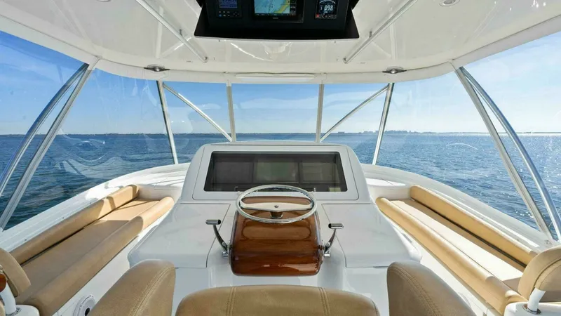 Slide: The Image of Flybridge Helm with Panoramic Views The flybridge helm of the 2013 Viking 55 Convertible offers commanding views with its expansive wrap-around windows. The helm features a sleek wooden steering console and state-of-the-art navigation equipment. Complemented by plush seating, this space com - 7594272