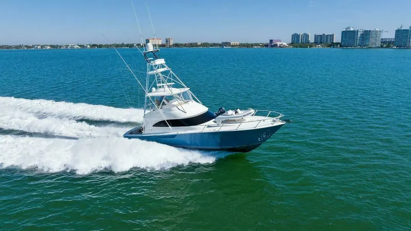 Slide: The Image of Viking 55 Convertible Cruising View The 2013 Viking 55 Convertible 'Hot Spot' is captured cruising effortlessly across vibrant blue waters. Its sleek hull design ensures a smooth ride, while the spacious flybridge offers excellent visibility and command. This image highlights the yacht's po - 7594314
