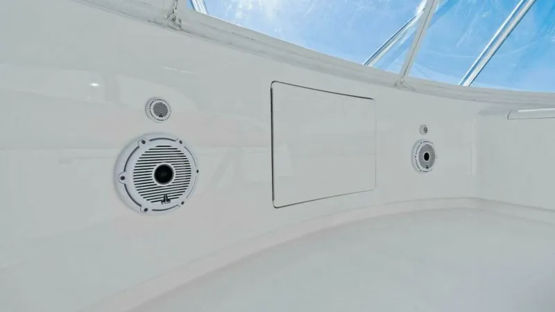 Slide: The Image of Flybridge Helm Station Detail This image showcases the sleek and modern design of the flybridge helm station on the 2013 Viking 55 Convertible. The area is equipped with high-quality marine speakers, providing excellent audio for onboard entertainment. The clean lines and bright white - 7594257