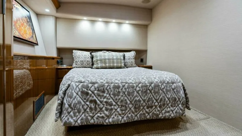 Slide: The Image of Luxurious Master Stateroom This elegant master stateroom on the 2013 Viking 55 Convertible 'Hot Spot' features a plush queen-size bed adorned with a stylish patterned comforter. The room is illuminated by recessed lighting that highlights the warm wood finishes and contemporary wal - 7594250