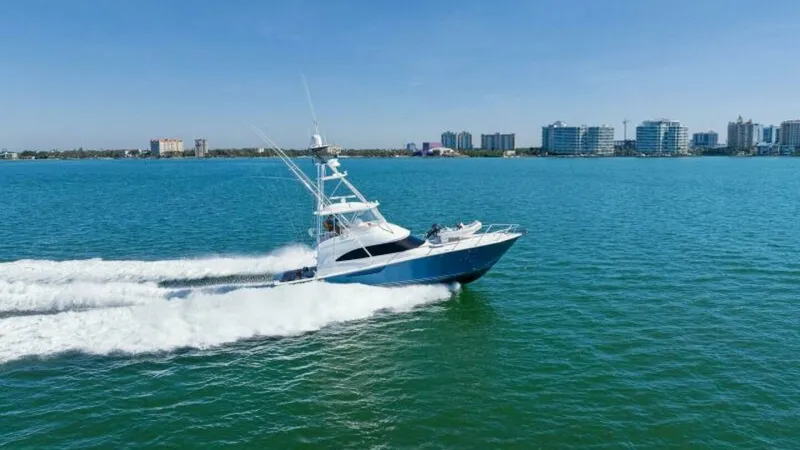 Slide: The Image of Viking 55 Convertible in Motion The 2013 Viking 55 Convertible, 'Hot Spot', is captured slicing through the open water, showcasing its sleek design and robust performance. The vessel's distinctive blue hull and sophisticated tower stand out against the vibrant sea, emphasizing its sport - 7594308