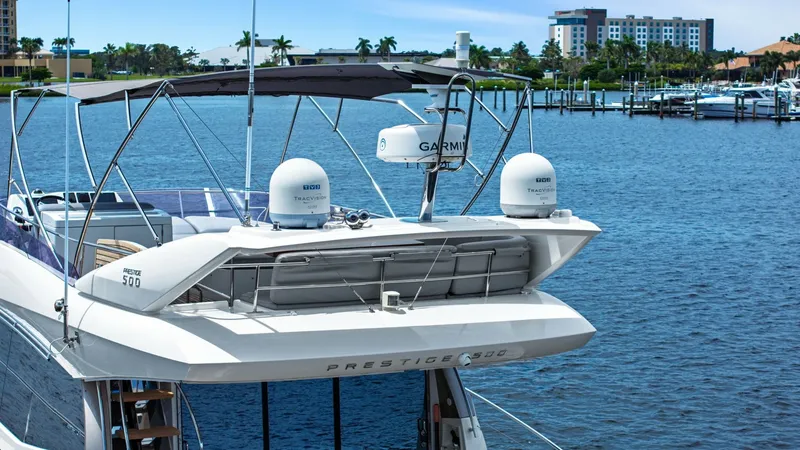 Slide: The Image of Flybridge with Radar and Canopy The Prestige 500 Fly showcases a well-equipped flybridge featuring advanced radar systems from Garmin, providing excellent navigational capabilities. A sleek, modern canopy offers shade and comfort, ideal for cruising in various weather conditions. The fl - 7603826