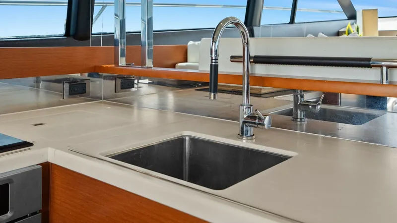 Slide: The Image of Elegant Galley Countertop and Sink This image showcases the sleek galley area of the Prestige 500 Fly, featuring a modern countertop with a stainless steel sink. The high-gloss wood finishes and clean lines create a sophisticated ambiance, complemented by ample natural light from the large - 7603781