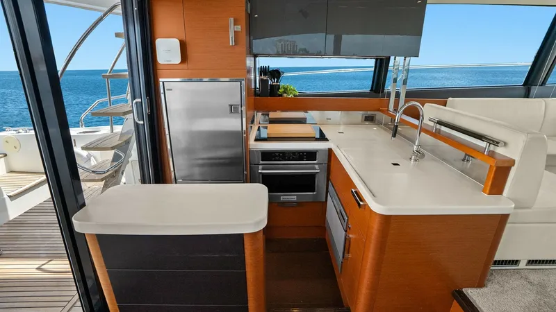 Slide: The Image of Galley with Ocean View This modern galley on the Prestige 500 Fly offers a sleek and functional space, featuring high-quality stainless steel appliances and stylish cabinetry. The large windows provide ample natural light and stunning ocean views, enhancing the open and invitin - 7603777